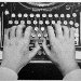 main qui tape sur une ancienne machine à écrire